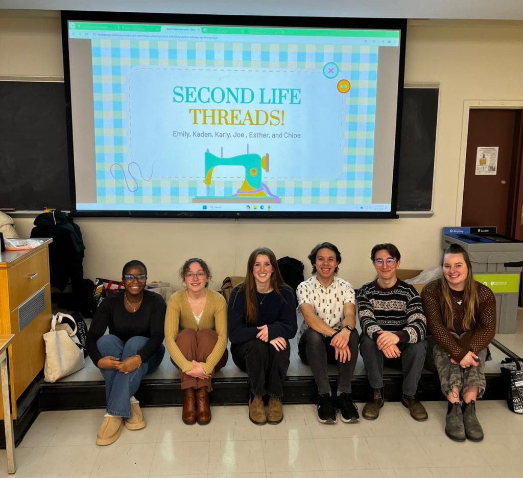 Photo of the Second Life Threads team sitting in front of a presentation's title slide at the Textile Turnaround event.